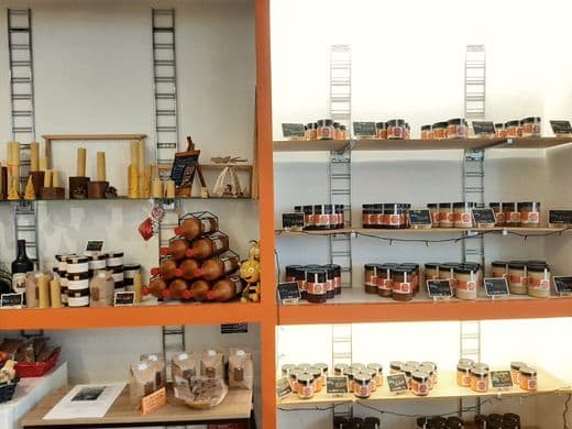 Les rayons du magasin : pots de miel, bougies en cire d'abeille et produits de la ruche.
